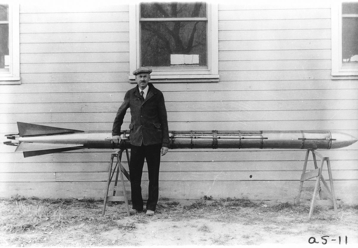 Robert Goddard posing in front of one of his rockets in 1911