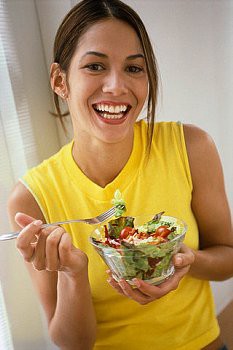 woman laughing alone with salad?