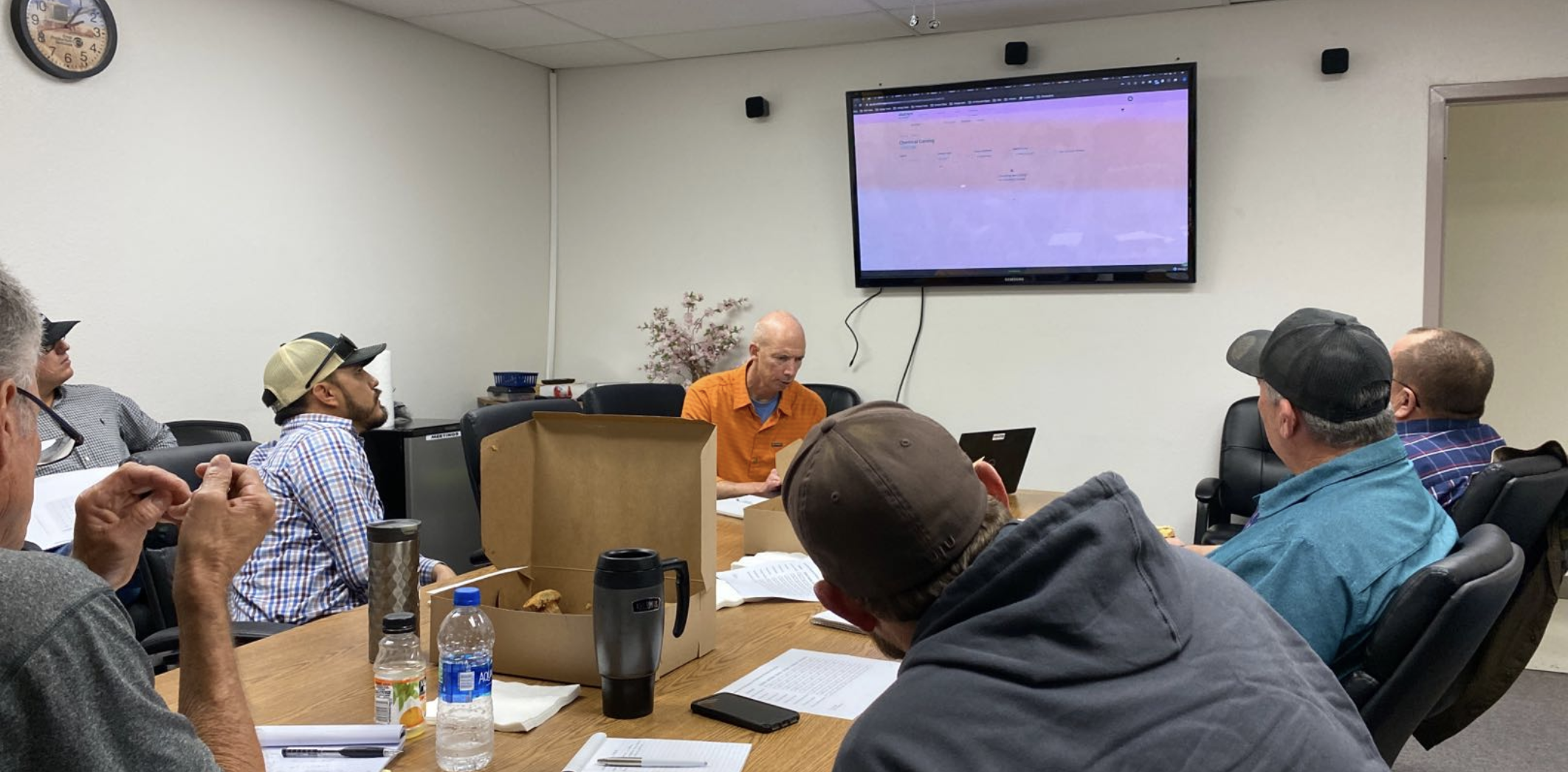 A field research session: crop consultants gathered around a conference table reviewing the platform on screen.
