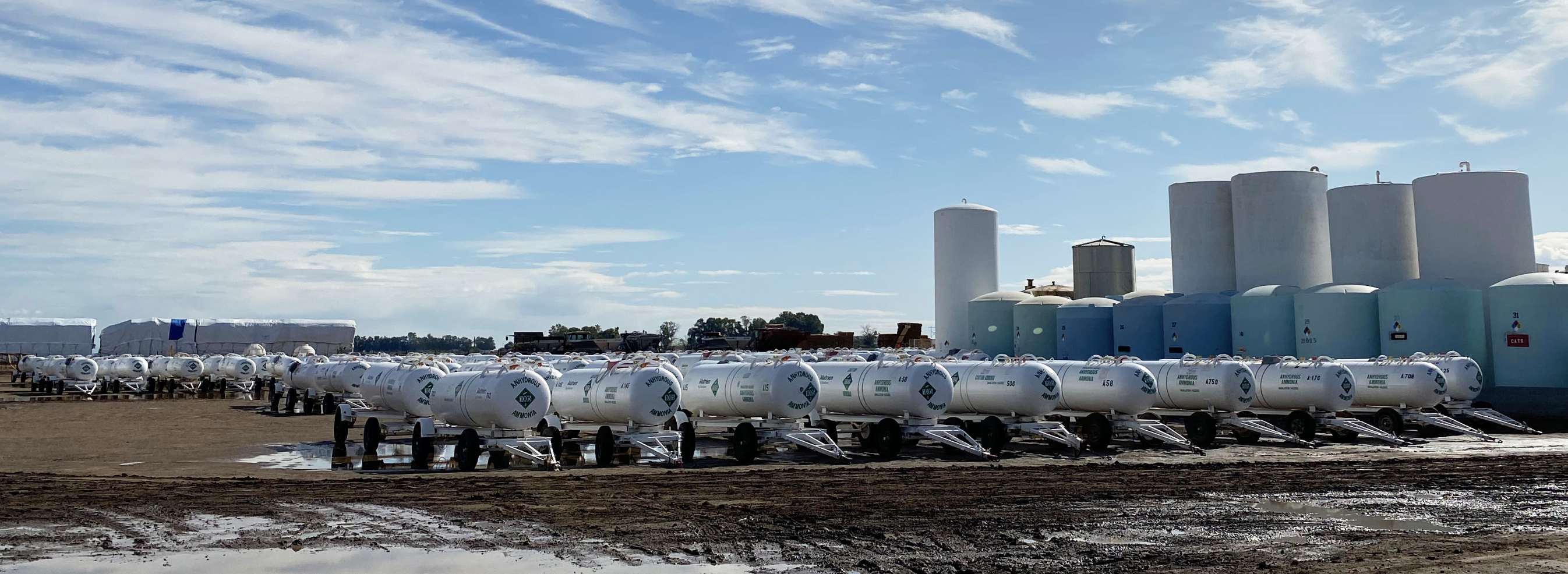 Rows of fertilizer tanks and product stock at a Nutrien facility — a glimpse of the enormous catalog a crop consultant has to navigate.